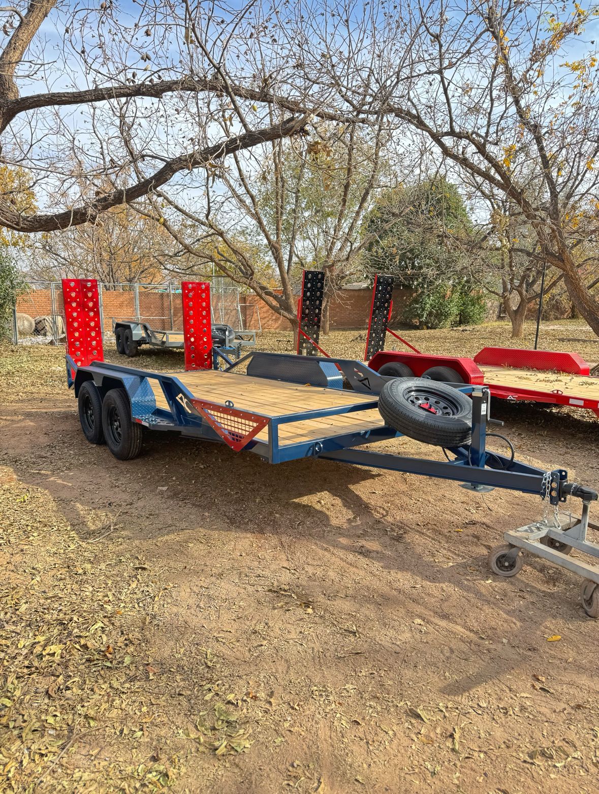 Custom equipment trailer with blue and red color scheme and loading ramps - AC Solutions Industries El Paso